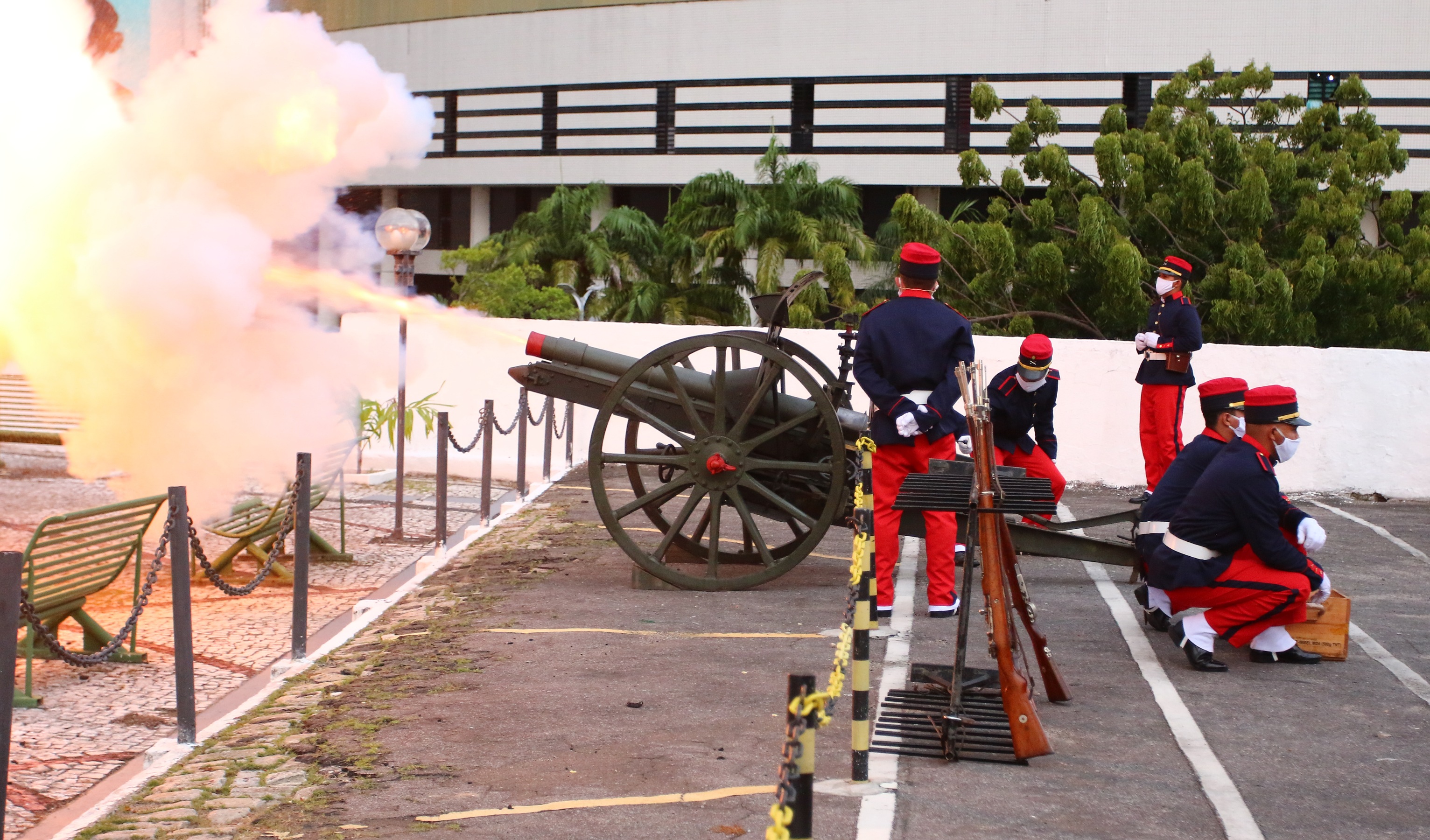 grupo de soldados manuseando canhão atirando com fumaça e faíscas